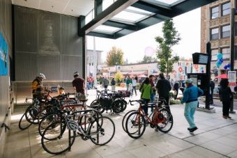 Link light rail station bicycle rack with many bikes and people nearby.